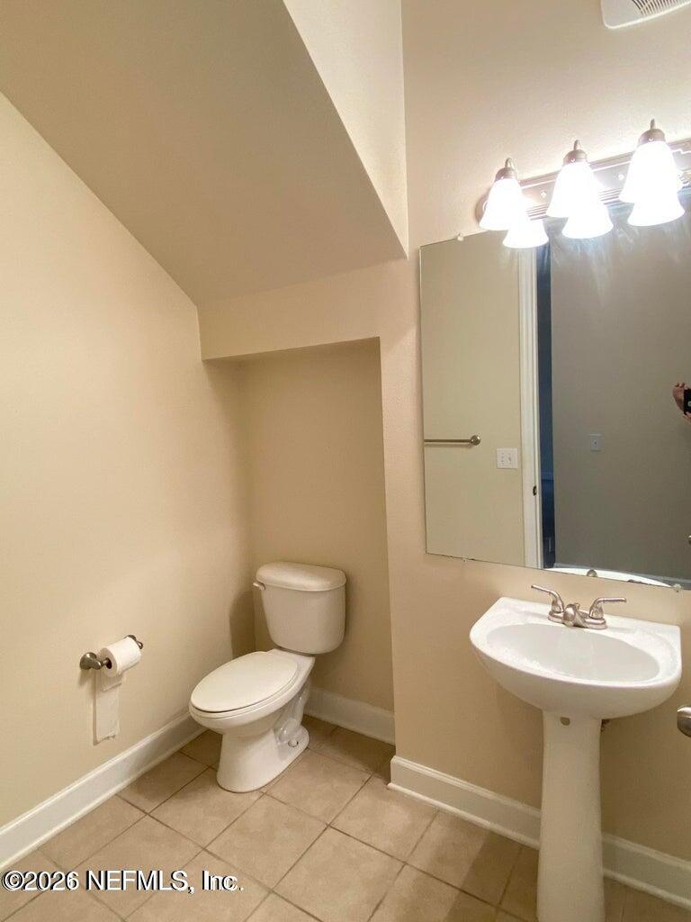 2035 Secret Garden Lane, Unit 504 Fleming Island, FL 32003 - Photo 13 of 32 a bathroom with a sink toilet and a mirror