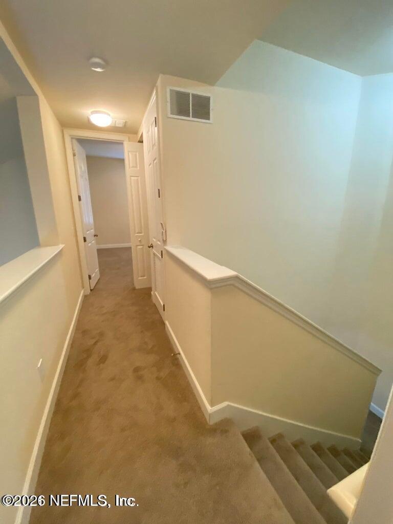 2035 Secret Garden Lane, Unit 504 Fleming Island, FL 32003 - Photo 14 of 32 a view of a hallway with wooden floor and staircase