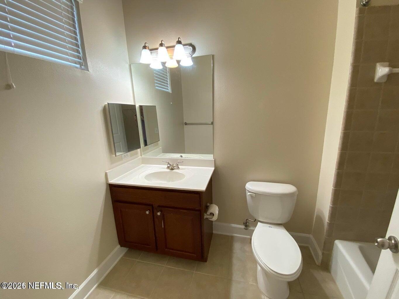 2035 Secret Garden Lane, Unit 504 Fleming Island, FL 32003 - Photo 16 of 32 a bathroom with a toilet sink and mirror