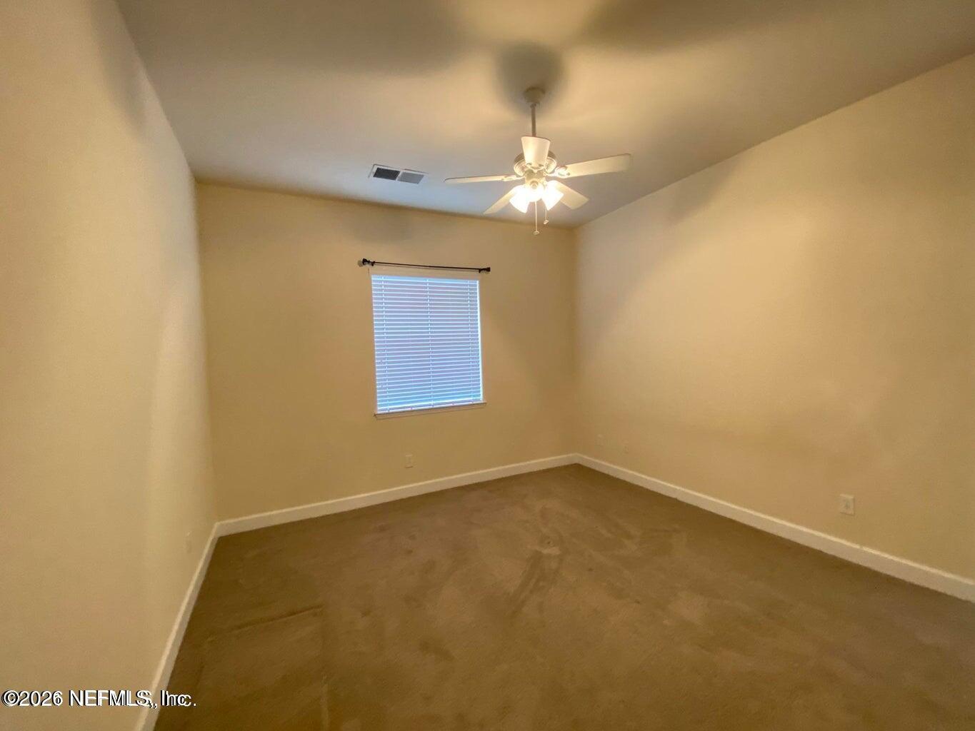2035 Secret Garden Lane, Unit 504 Fleming Island, FL 32003 - Photo 19 of 32 an empty room with a chandelier fan and a table