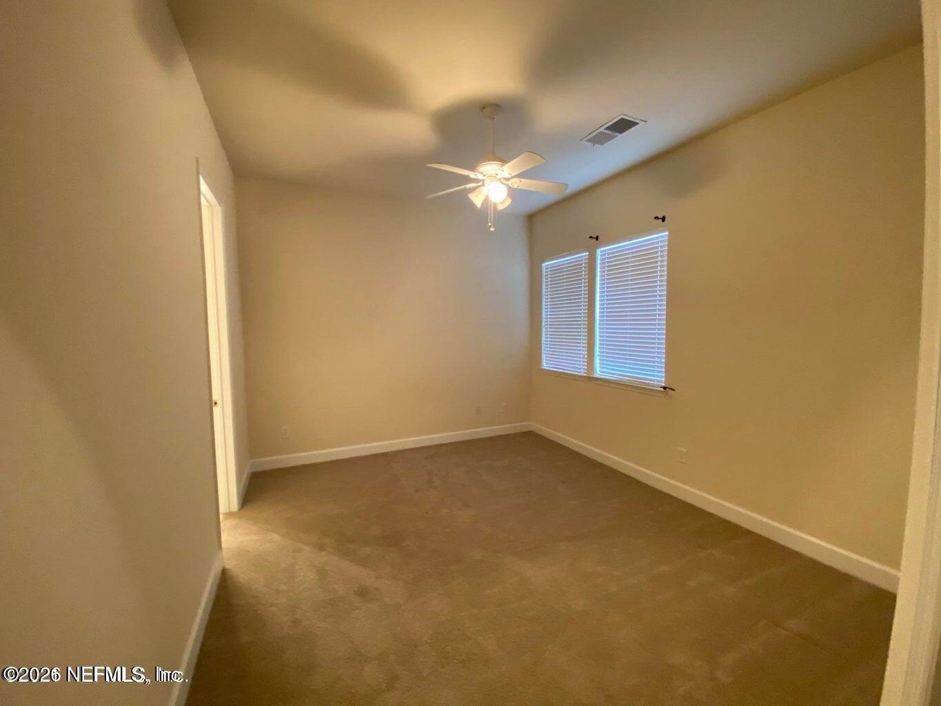 2035 Secret Garden Lane, Unit 504 Fleming Island, FL 32003 - Photo 24 of 32 an empty room with windows and fan