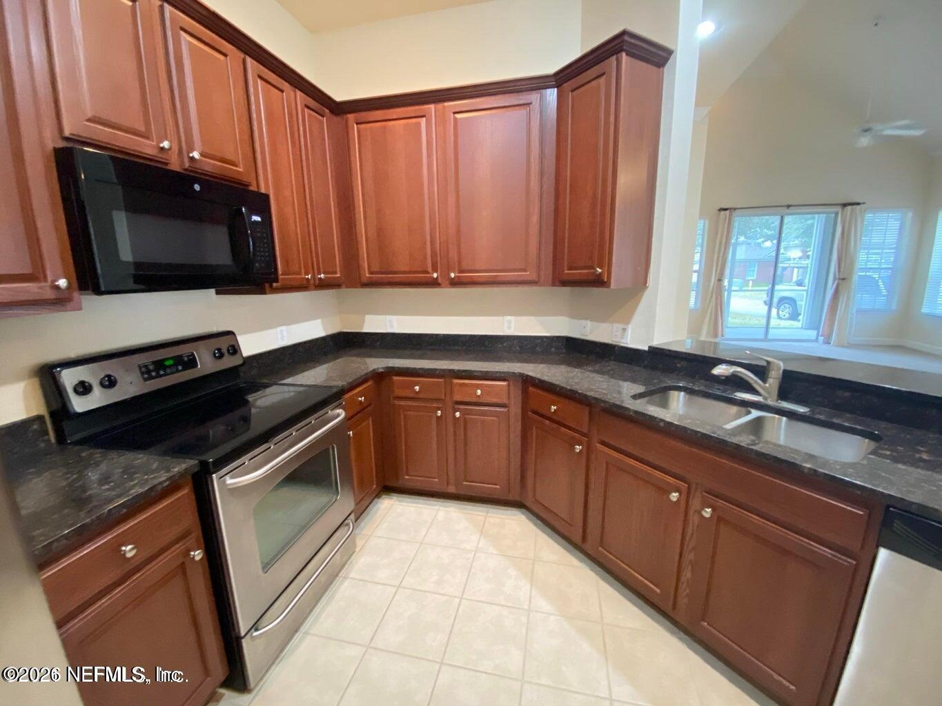 2035 Secret Garden Lane, Unit 504 Fleming Island, FL 32003 - Photo 28 of 32 a kitchen with a sink stove and microwave
