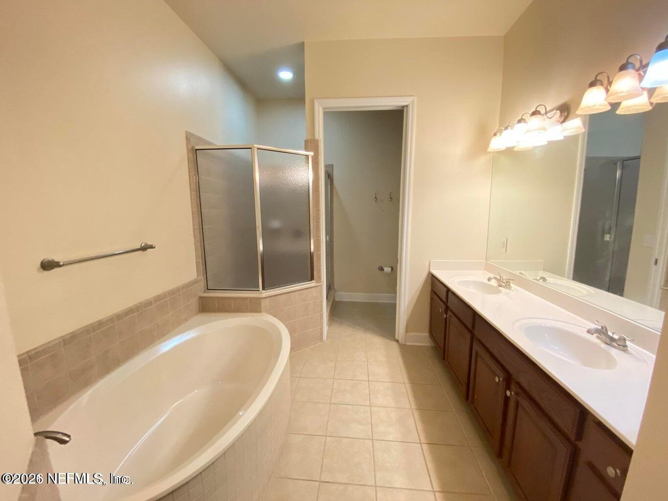 2035 Secret Garden Lane, Unit 504 Fleming Island, FL 32003 - Photo 8 of 32 a spacious bathroom with a tub sink and mirror