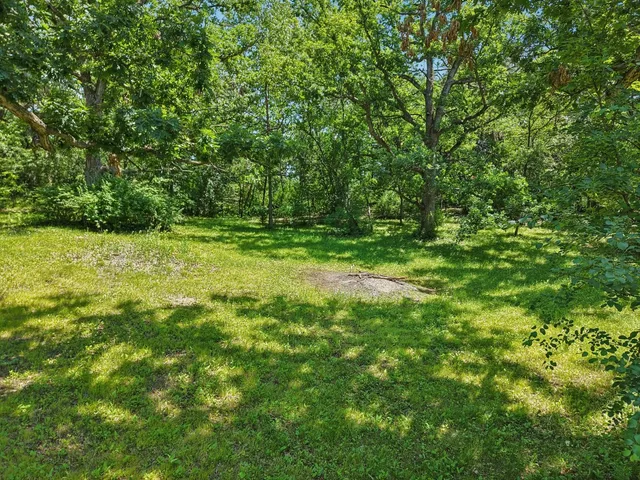 a view of outdoor space with a field and trees