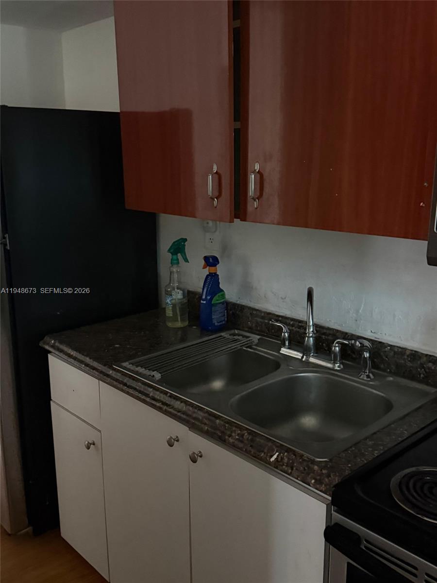 a kitchen with granite countertop a sink stove and cabinets