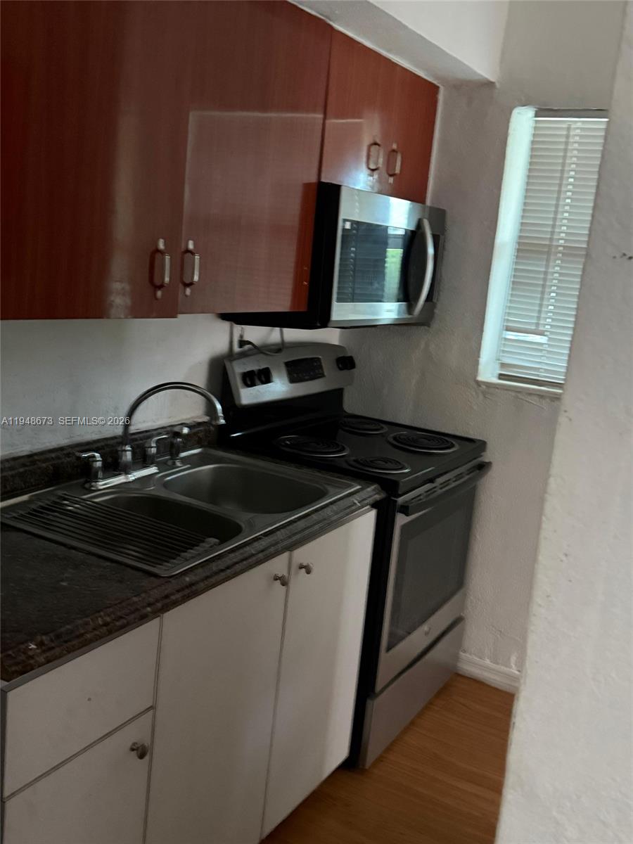 2247 Simms Street, Unit 2 Hollywood, FL 33020 - Photo 2 of 9 a kitchen with stainless steel appliances a sink stove and microwave