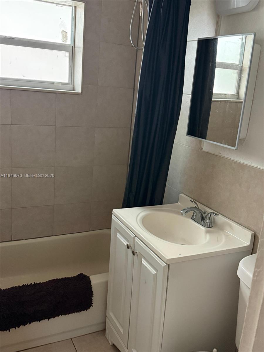 2247 Simms Street, Unit 2 Hollywood, FL 33020 - Photo 4 of 9 a bathroom with a sink a toilet and a mirror