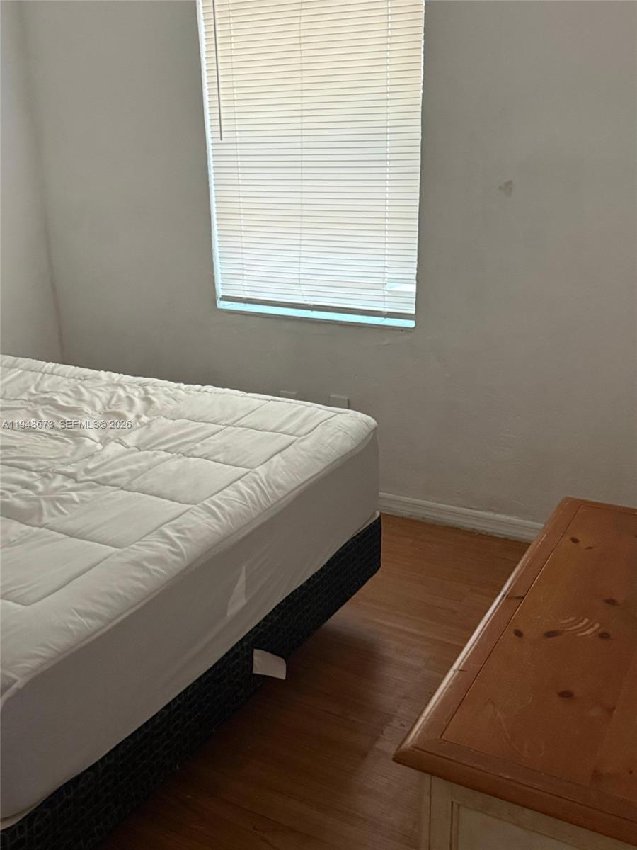 2247 Simms Street, Unit 2 Hollywood, FL 33020 - Photo 7 of 9 a bed sitting in a bedroom next to a window
