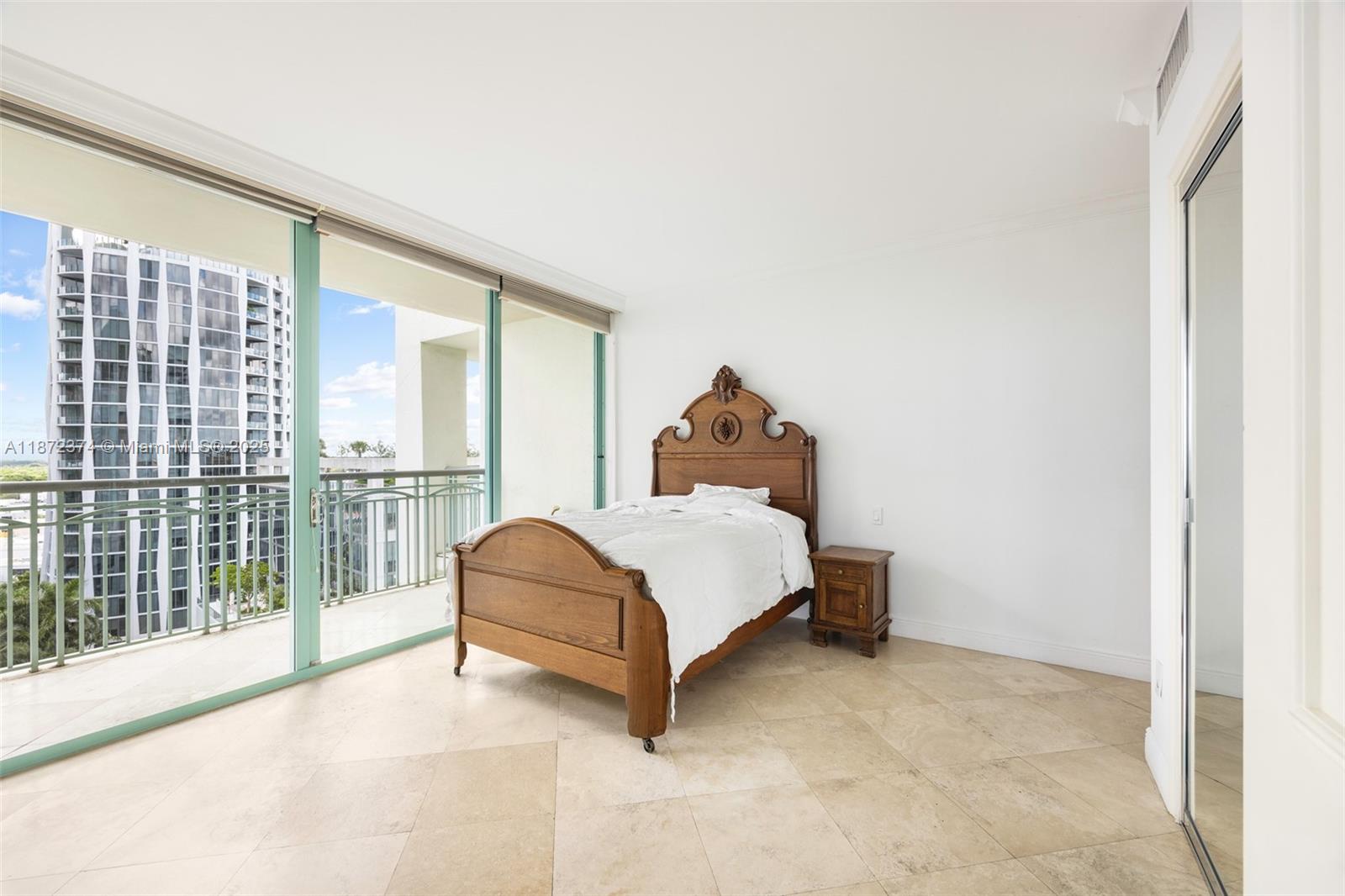 3350 Southwest 27th Avenue, Unit 1402 Miami, FL 33133 - Photo 14 of 23 a bed sitting in a room next to a window
