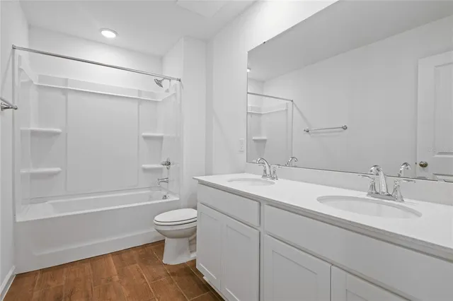 a bathroom with a sink a toilet and a large mirror