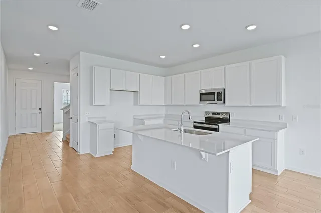 a kitchen with white cabinets and stainless steel appliances