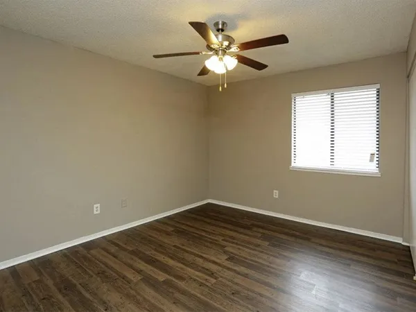 a view of a room with wooden floor and fan