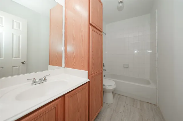 an empty room with wooden floor window and ceiling fan