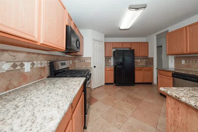 a kitchen with granite countertop cabinets stainless steel appliances and a sink