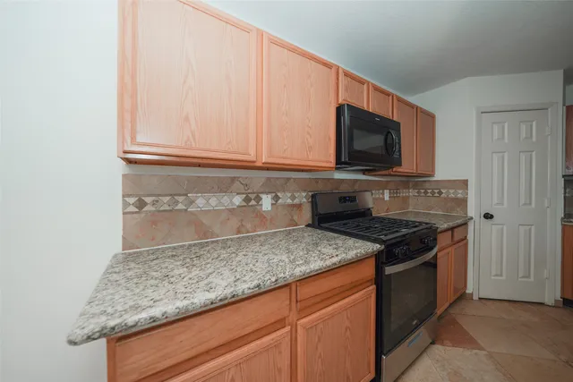a kitchen with granite countertop cabinets and refrigerator