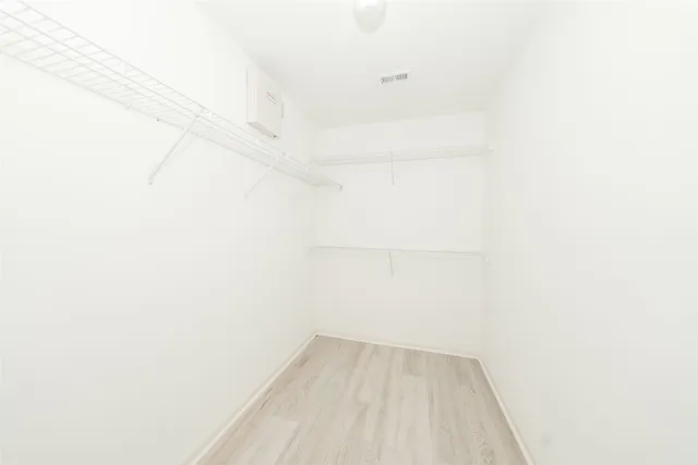 an empty room with a window and a ceiling fan