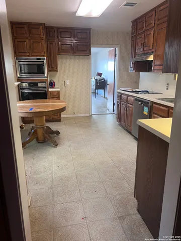 a kitchen with stainless steel appliances a stove a sink and a refrigerator