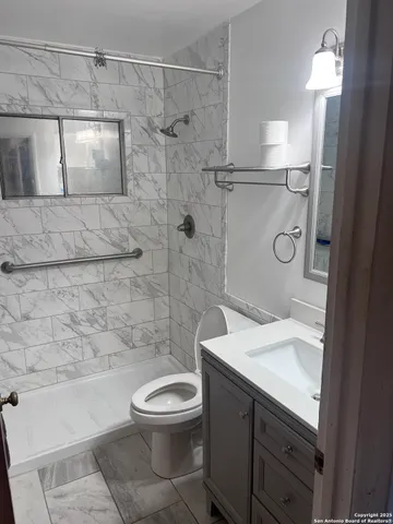 a bathroom with a sink a toilet and shower