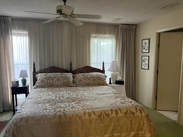 a bedroom with a large bed and a chandelier