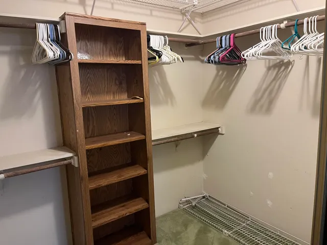 a view of walk in closet with empty racks
