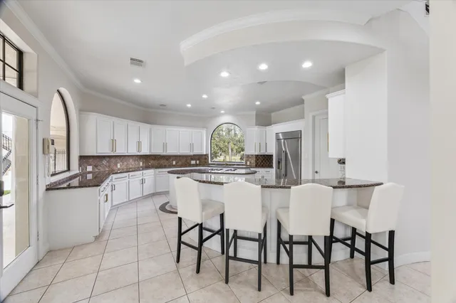 a kitchen with a sink a stove a refrigerator cabinets and dining table