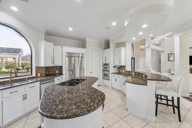 a kitchen with stainless steel appliances granite countertop a stove a sink and a refrigerator