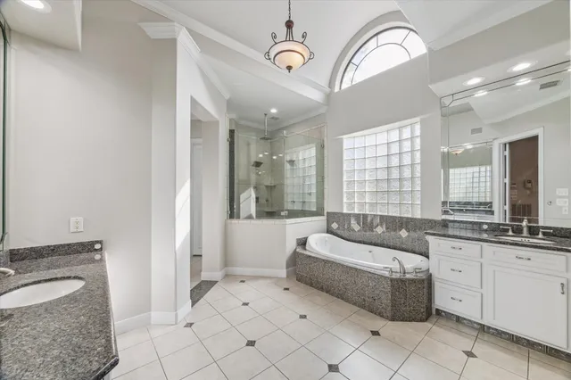 a spacious bathroom with a granite countertop tub sink a mirror a shower and vanity