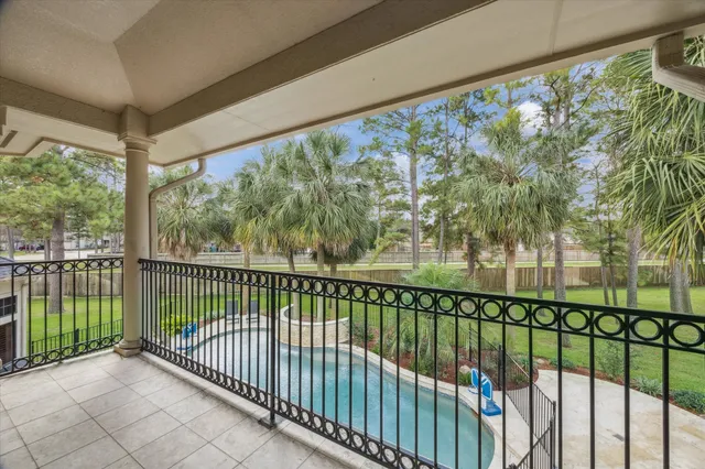 a view of a backyard with table and chairs potted plants and large tree