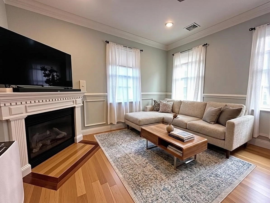 6 Wyman Street, Unit 3 Boston, MA 02130 - Photo 2 of 9 a living room with furniture a flat screen tv and a fireplace