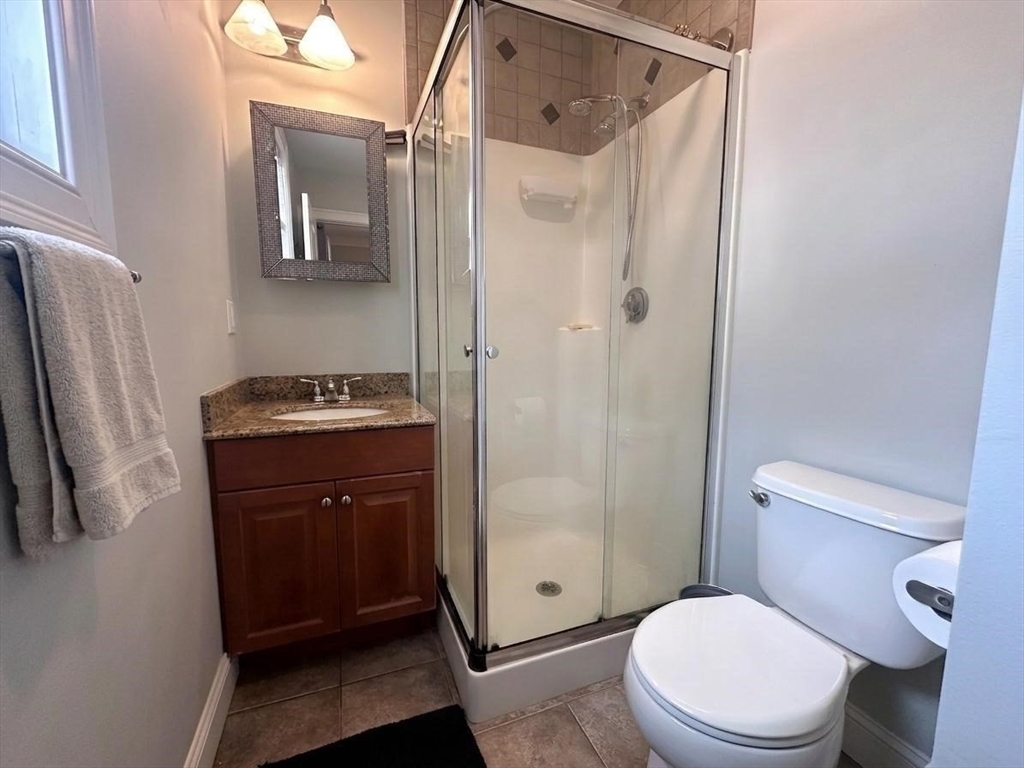 6 Wyman Street, Unit 3 Boston, MA 02130 - Photo 5 of 9 a bathroom with a toilet a sink and shower