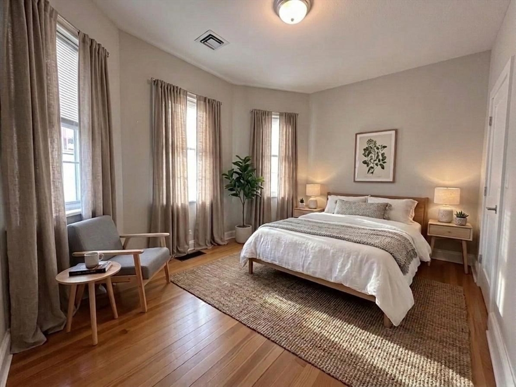 6 Wyman Street, Unit 3 Boston, MA 02130 - Photo 6 of 9 a spacious bedroom with a bed a table and chair