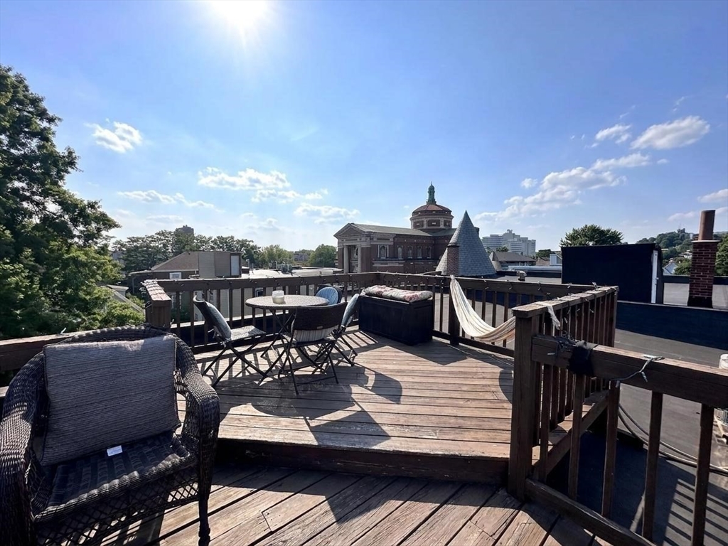6 Wyman Street, Unit 3 Boston, MA 02130 - Photo 9 of 9 a view of a roof deck with table and chairs a barbeque with wooden floor and fence