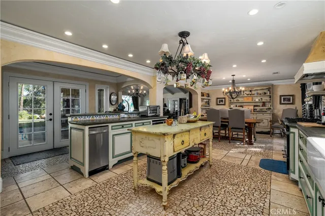 a large white kitchen with a large counter top and stainless steel appliances