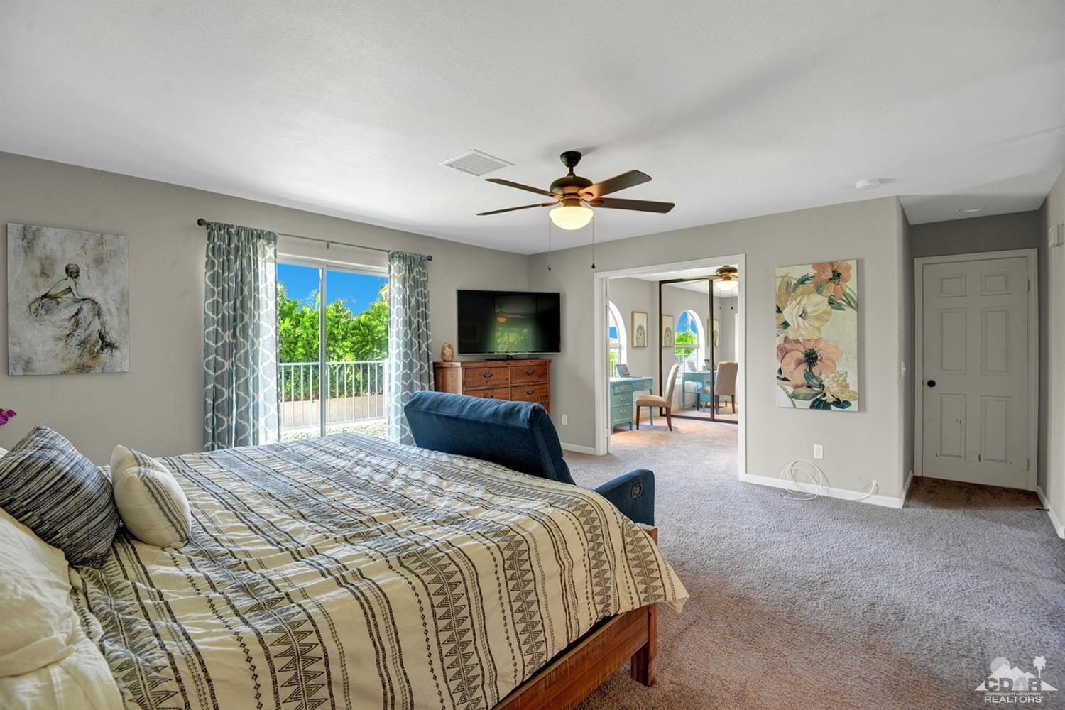 68710 Raposa Road Cathedral City, CA 92234 - Photo 16 of 29 a bedroom with a large bed a window and a chandelier