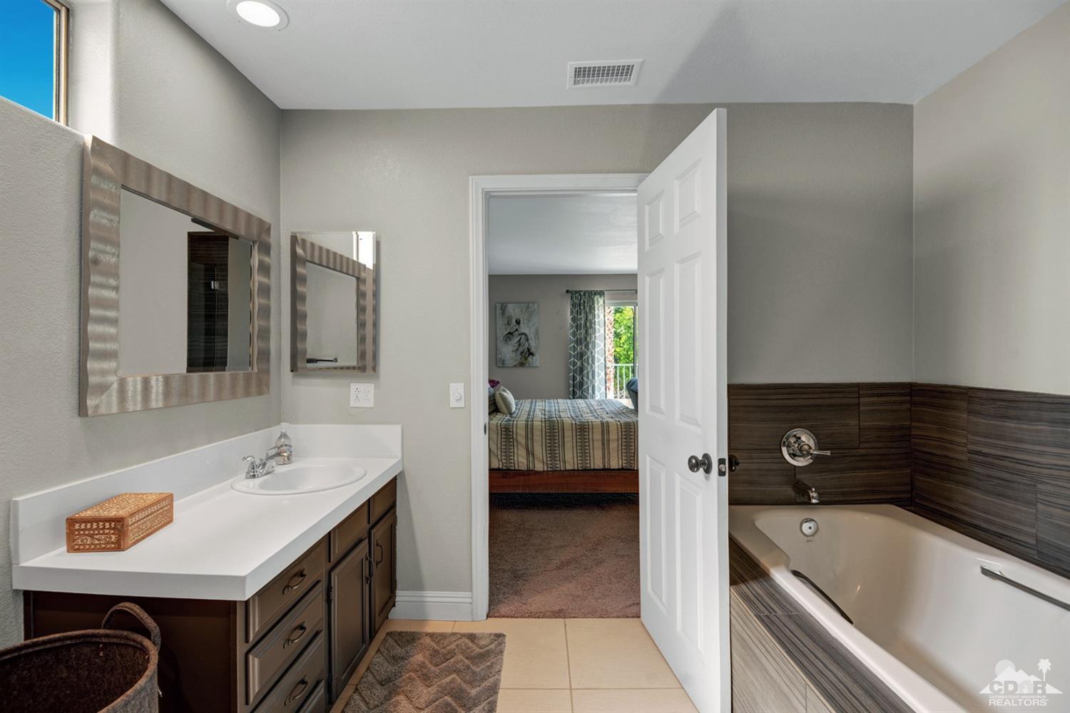 68710 Raposa Road Cathedral City, CA 92234 - Photo 18 of 29 a spacious bathroom with a tub sink and mirror