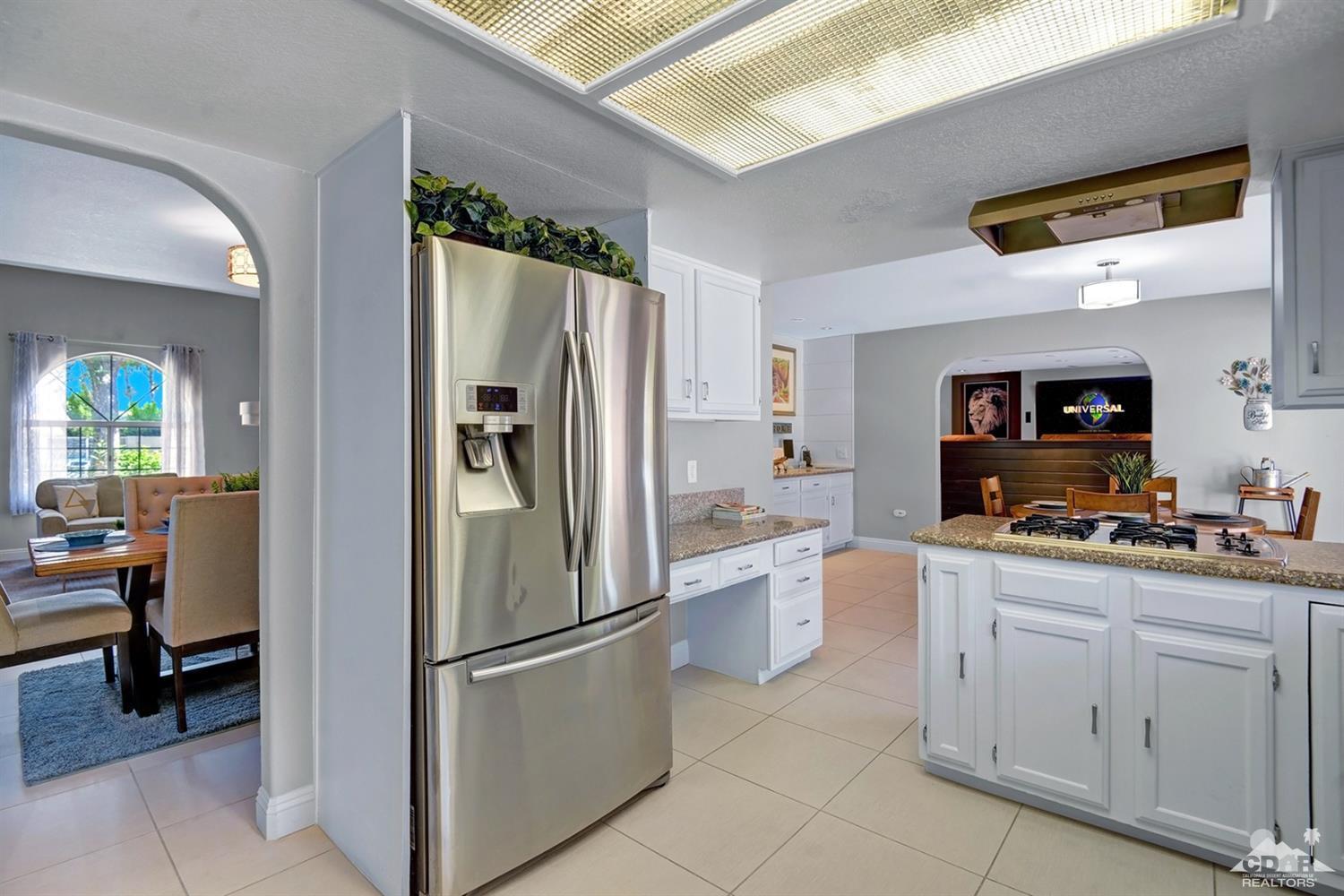 68710 Raposa Road Cathedral City, CA 92234 - Photo 5 of 29 a kitchen with white cabinets and refrigerator