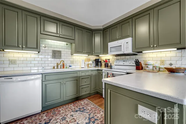 a kitchen with stainless steel appliances a sink a stove a refrigerator and cabinets
