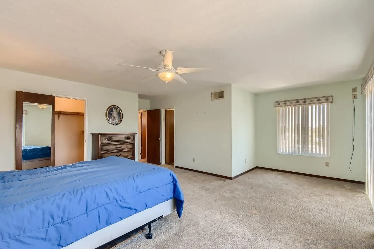 396 El Monte Road El Cajon, CA 92020 - Photo 12 of 18 a spacious bedroom with a bed and a chandelier