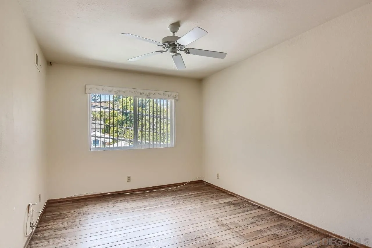 396 El Monte Road El Cajon, CA 92020 - Photo 15 of 18 an empty room with wooden floor fan and windows