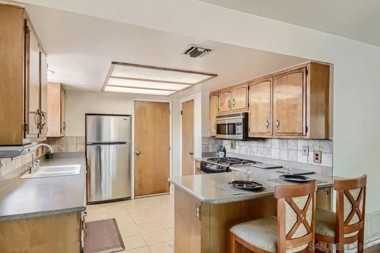 396 El Monte Road El Cajon, CA 92020 - Photo 6 of 18 a kitchen with stainless steel appliances a stove a sink refrigerator and a microwave