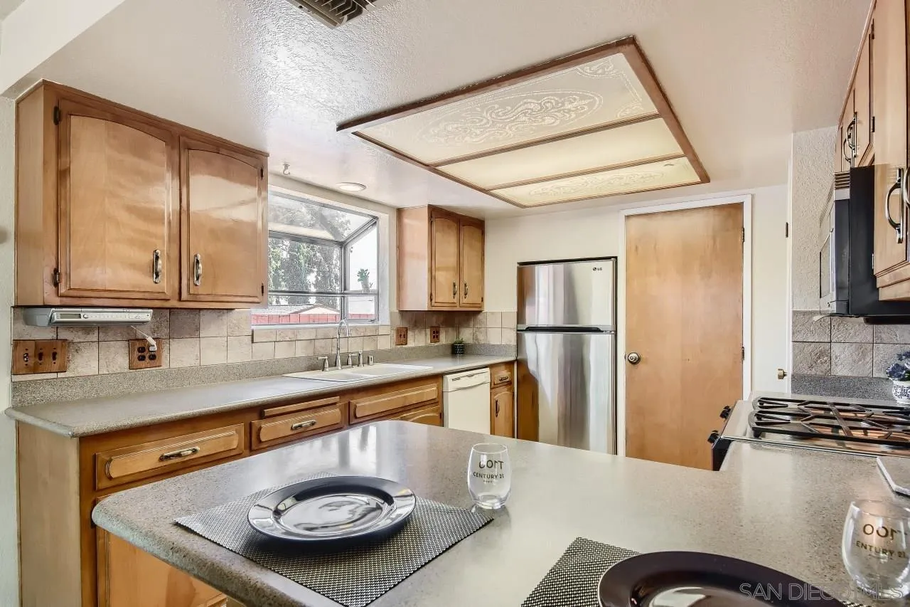 396 El Monte Road El Cajon, CA 92020 - Photo 7 of 18 a kitchen with stainless steel appliances granite countertop a sink stove and refrigerator