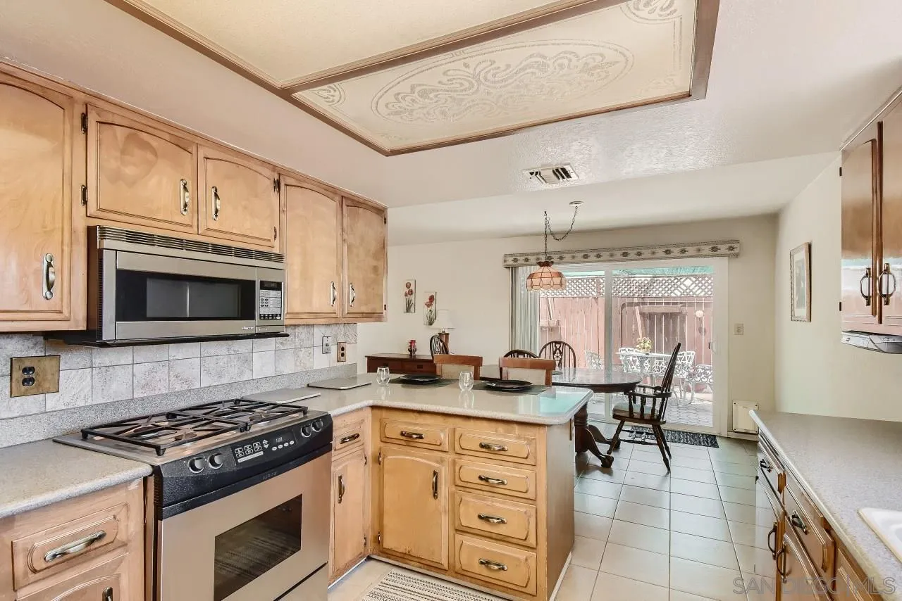 396 El Monte Road El Cajon, CA 92020 - Photo 8 of 18 a kitchen with granite countertop a stove top oven microwave and cabinets