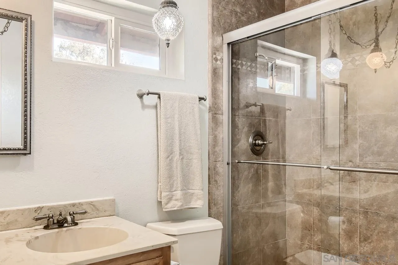 396 El Monte Road El Cajon, CA 92020 - Photo 10 of 18 a bathroom with a sink mirror toilet and shower