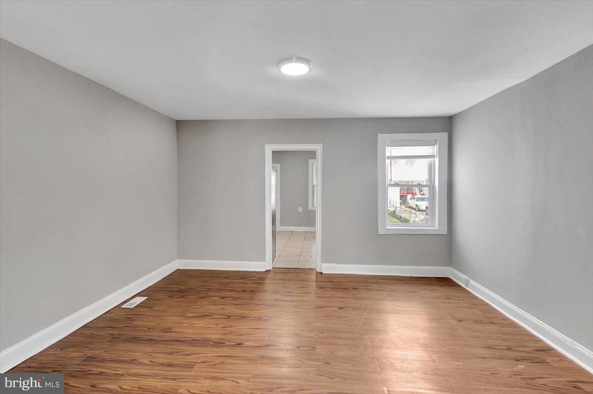 74 South Kossuth Street Baltimore, MD 21229 - Photo 18 of 18 an empty room with wooden floor and windows