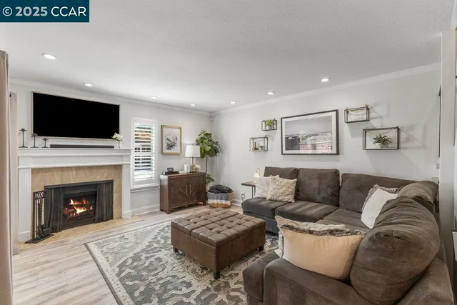 a living room with furniture a flat screen tv and a fireplace