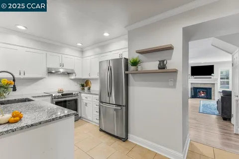 a kitchen that has a lot of cabinets in it and wooden floors