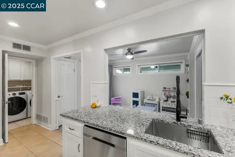 a kitchen with stainless steel appliances granite countertop a sink a stove and cabinets