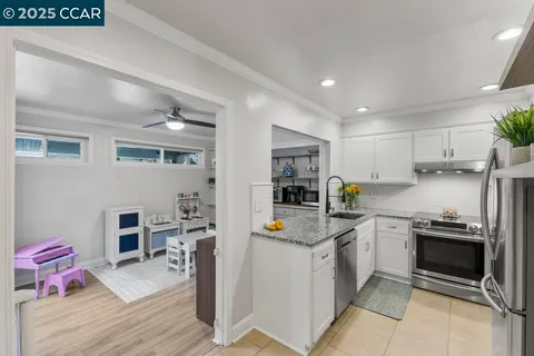 a kitchen with granite countertop a refrigerator and a stove top oven
