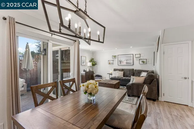 a view of a dining room with furniture a chandelier and wooden floor