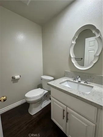 a bathroom with a granite countertop toilet sink and mirror